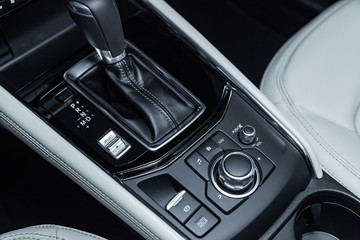 Fototapeta na wymiar Сlose-up of the car black interior: dashboard, accelerator handle, parking systems, seats and other buttons.