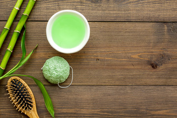 Spa composition. Natural asian spa cosmetics near bamboo on dark wooden background top view space for text