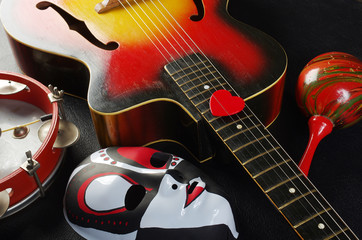 Acoustic guitar, masquerade mask, tambourine, maracas.