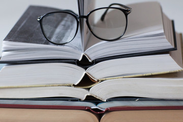 Stack of books and glasses on white background. Morning. Study. Education.