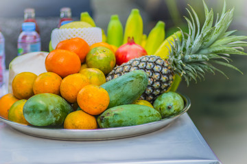 Set of fresh tropical fruits including banana, orange, pineapple, fresh water, red water, coconut, apple, mango, grape, longan, prepared for the spirits of the gods  worship ceremony