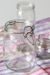Empty glass jars on a striped dish towel. Glass