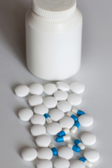 Medicine. Virus. Treatment. A bottle of spilled pills on the white background