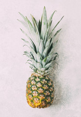 Ripe pineapple on grey textured background