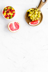 Healthy diet concept. Fruit salad near fresh fruits on white background top view copy space