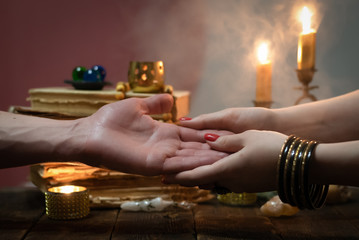 Palmistry concept. Fortune teller reading future on the hand on a magic table background. Future...
