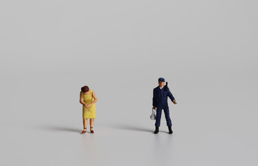 Miniature man police standing side by side with a miniature woman.