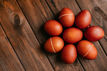 Red natural colored Easter eggs flatlay on the wooden background.
