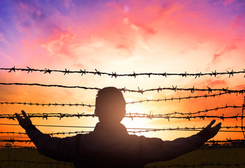 social justice abstract concept: with blurry barbed wire rod fence