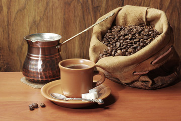 Coffee set. A cup of coffee, a coffee pot and a bag of coffee beans.