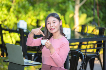 Women are selling products through social media using online notebooks at coffee shops.
