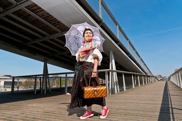Femme ombrelle et sac à main osier sous la Passerelle Simone-de-Beauvoir
