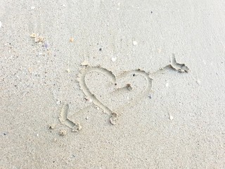 Drawing hearts on the sand beach, Sandy beach for background, Top view, space for your text, Valentine Day design, Love concept, greeting card, postcard, wedding invitation