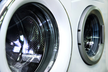 Round loading hatch of the industrial washing machine in the shop