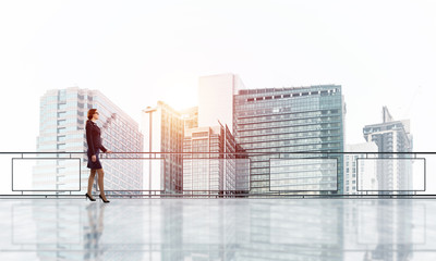 Sunrise above skyscrapers and businesswoman facing new day