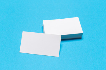 Blank white business cards on blue background. Mockup for branding identity.