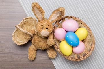 Easter eggs in the basket on wooden background