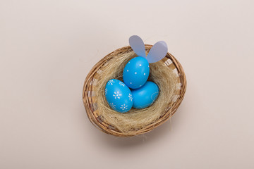 Blue easter eggs in nest on pastel color background with space. Concept