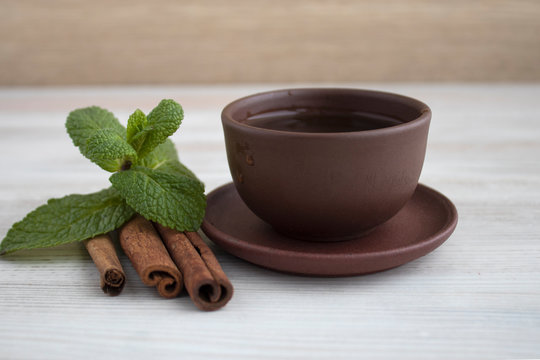 Mint and cinnamone tea on a white wood background