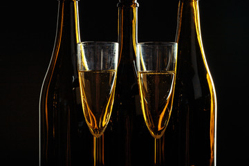 bottle of champagne and glasses over dark background