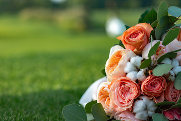 A wonderful colored bouquet of roses lies on the grass, a place for text .- Image