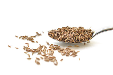 Cumin seed in a spoon on white background 