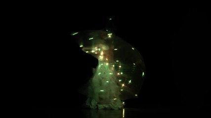 Belly dancer girl dance with two glowing lights wings. Black background. Sihouette