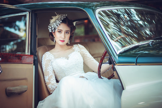 Portrait of young asian woman wearing a white dress with classic car. Concept beauty and fashion retro style