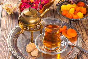 various dried fruits and  Turkish tea in Armudu glass on wooden table.