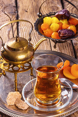 various dried fruits and  Turkish tea in Armudu glass on wooden table.