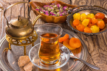 various dried fruits and  Turkish tea in Armudu glass on wooden table.