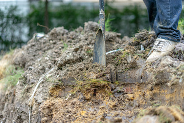 gardener digs the soil with his equipment for gardening and prepare land for plantation.