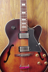 Fototapeta premium Jazz guitar on a wooden textured background. Close-up