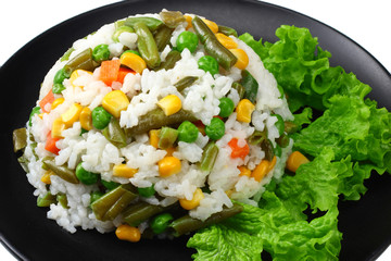black plate with white rice, green peas, canned corn kernels, cut green beans isolated on white background