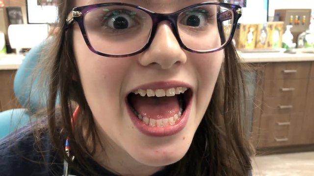 Young tween girl smiling with braces on