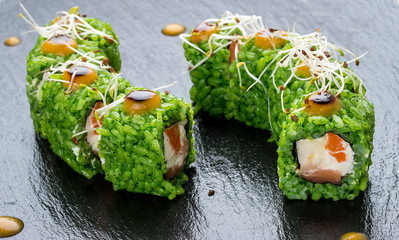 Sushi roll with salmon with micro green and green rice