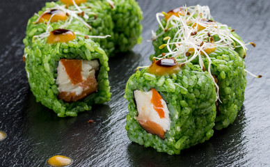 Sushi roll with salmon with micro green and green rice