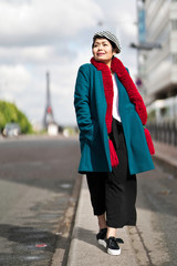 Obraz premium Femme marchant dans la rue avec tour eiffel en arrière plan