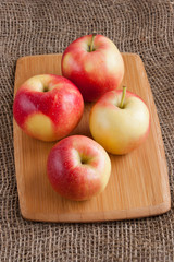 the apples on the cutting Board on a burlap