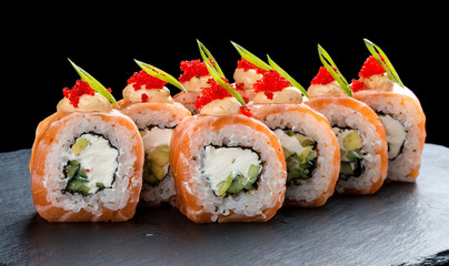Sushi roll with salmon and Philadelphia cheese on black background