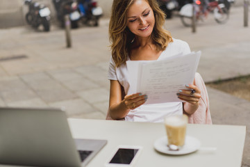 Happy smiling pretty girl having an online video lesson while sitting in a cafe, looking into...