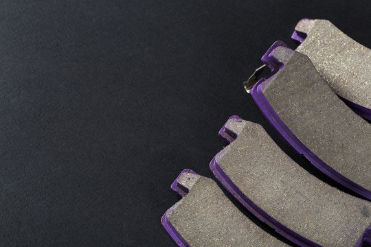 A set of new brake pads on a black background