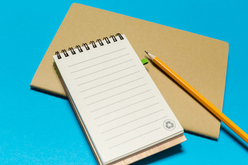 Blank paper notebook on blue background.
