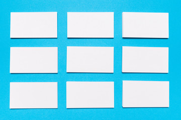 Blank white business cards on blue background. Mockup for branding identity.