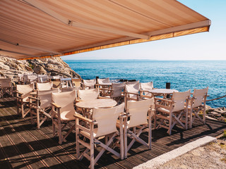 Traditional Greek Tavern near the sea with white wood furniture