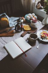 country cottage kitchen with breakfast on wooden table. Toast with jam, farm eggs and coffee
