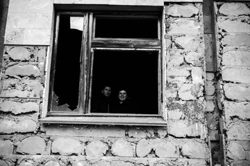 Those people in a dark black window of an abandoned building