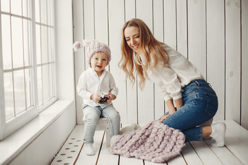 Cute little boy with mother. Family at home. Mother with son sitting near window