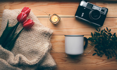tulips and a candle on a wooden background women's outfit and pistachio branches view from above