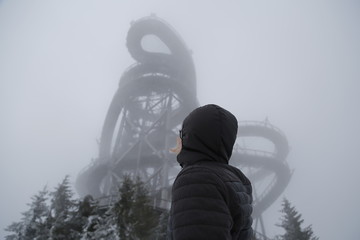 Back view of a young man looking at the tower. Winter, Sudety Mountains, Sky Walk, Dolní Morava, Dolni Morava, Czech Republic
